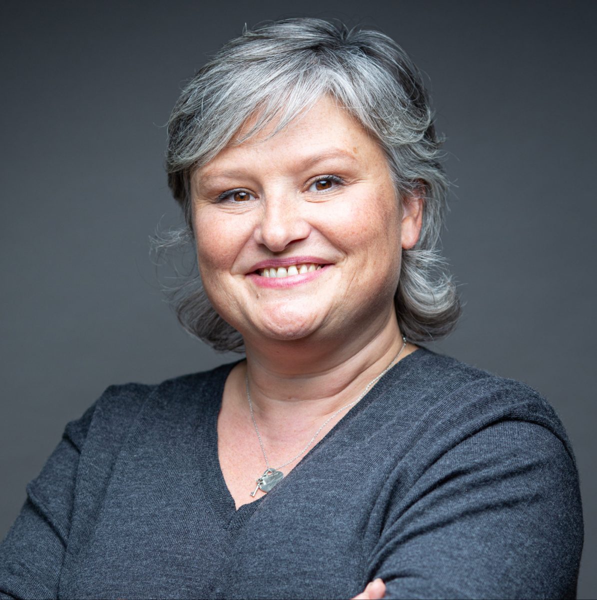 Femme aux cheveux poivre et sel souriante