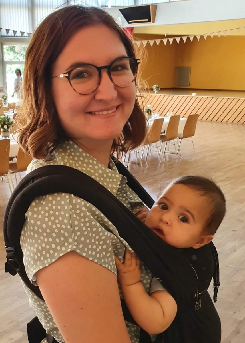 Jeune femme portrant un bébé sur le ventre en porte bébé