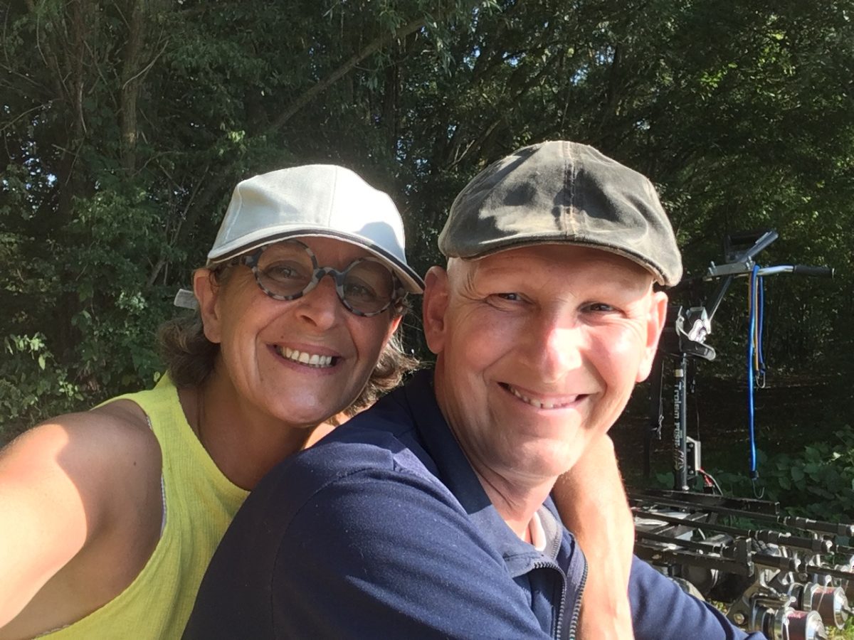 Femme dont le bras entoure les épaules d'un homme chauve. Les deux sourient