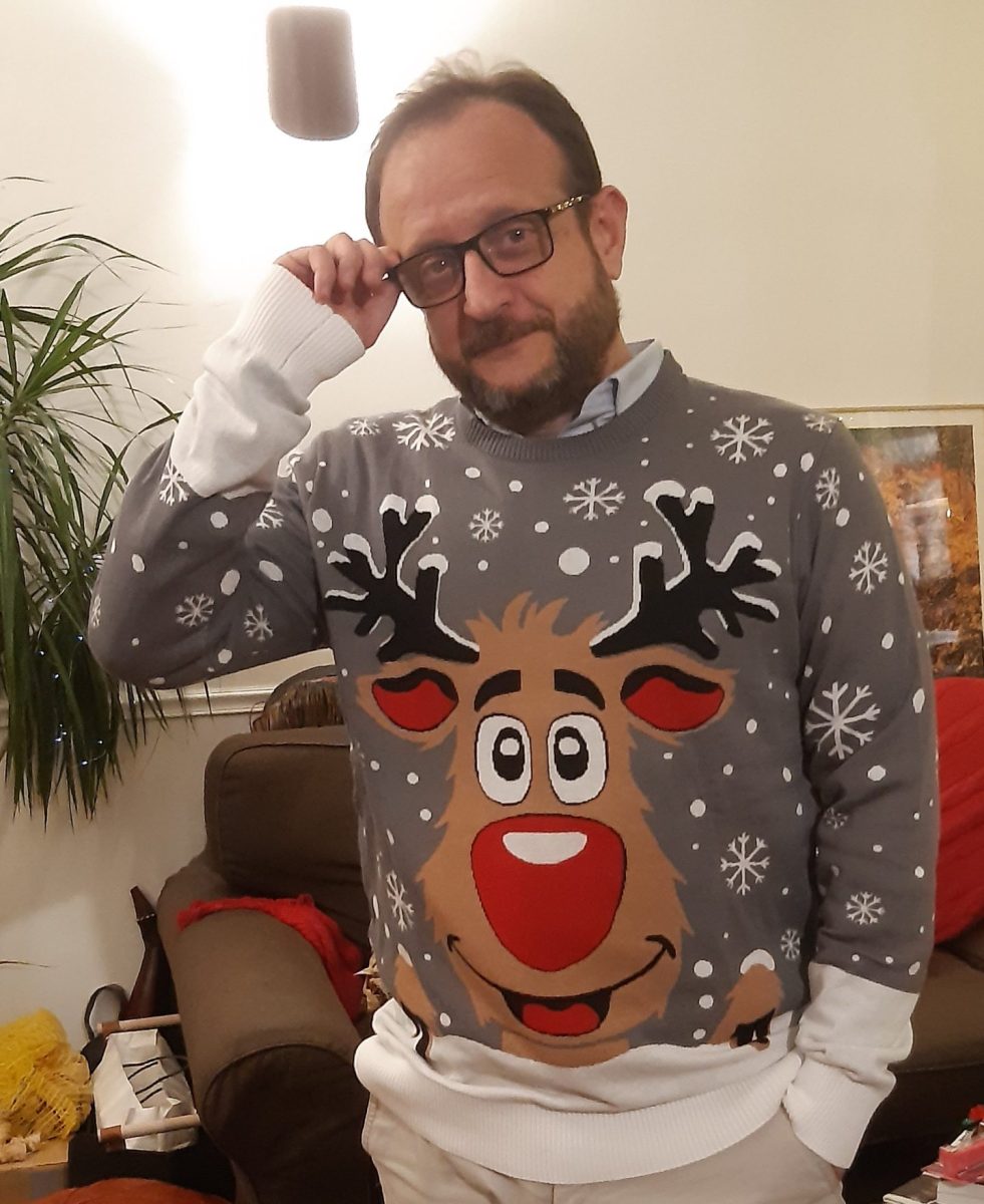 Homme qui porte un pull de noël moche avec un renne dessus
