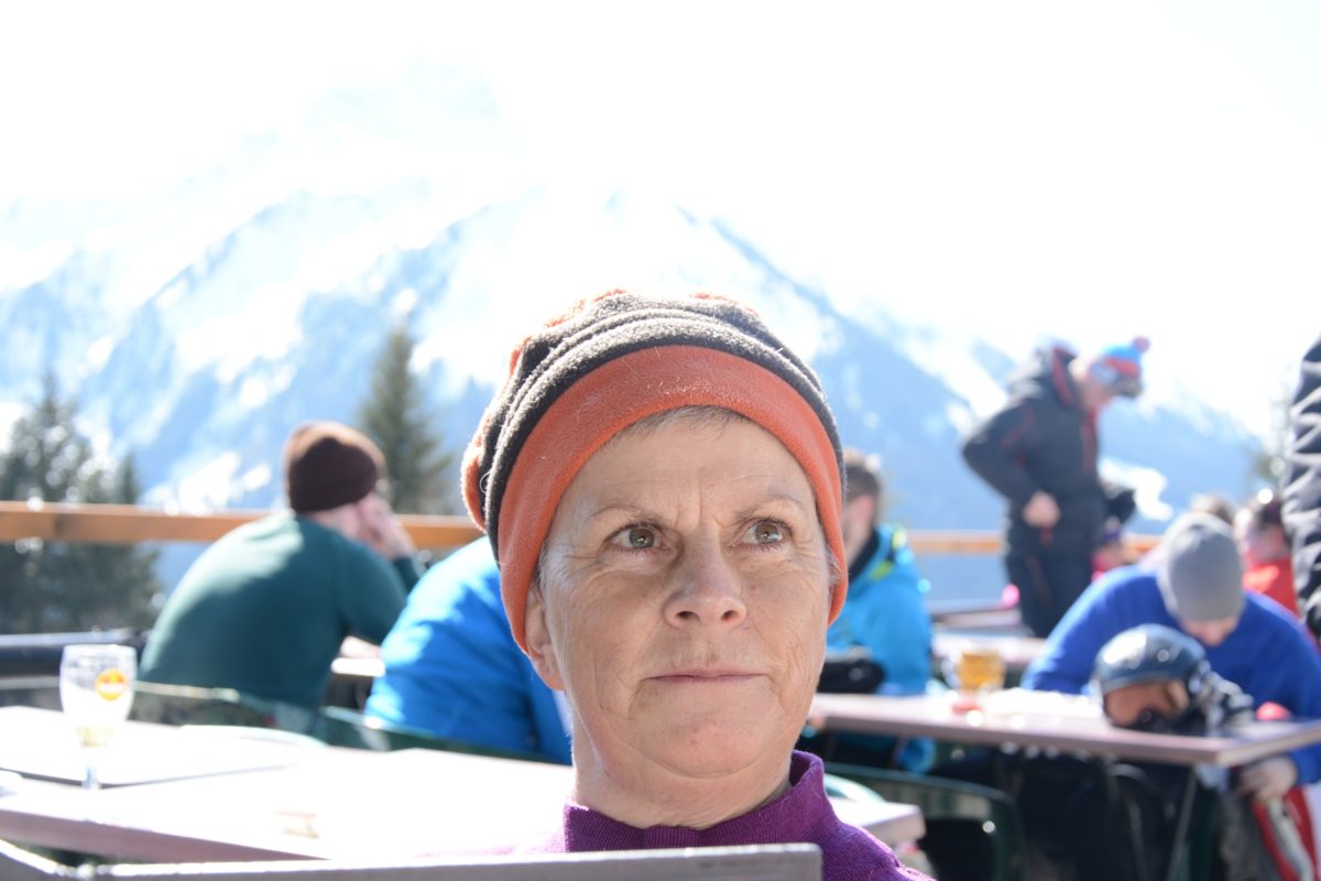 Femme portant un bonnet avant des montagnes enneigées en arrière fond